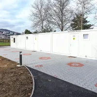 Lesene barake so porušili in tja  postavili sanitarije s prhami.