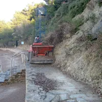   Z brežine nad plažo, na kateri se poleti kopa tudi po več sto otrok, pada kamenje. Jeseni je plaz zasul pešpot in stopnišče do morja. 