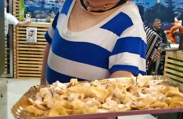 Izolska maskota Bepi obiskovalcem sejma ponuja kroštole in vino.