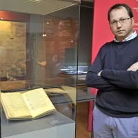 Dr. Andrej Nared, ki je zasnoval celotno razstavo, ob piranskem mestnem statutu iz leta 1307.