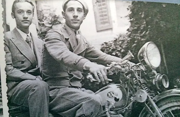 Rudolf Saksida ( na motorju zadaj)   se je rodil leta 1913 v Gorici, oče je bil po rodu iz vasi Saksid pri Dornberku, mati iz Brestovice na Krasu.
  