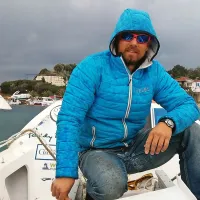 Namesto s Kreto v ozadju Marin Medak pozira v pristanišču 
Founikonto na Peloponezu.
