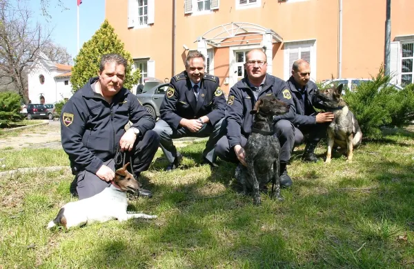 Vodniki službenih psov s svojimi štirinožnimi pomočnicami,  
izurjenimi za iskanje prepovedanih drog. 