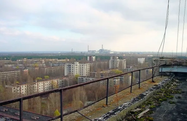 Zapuščeno mesto Pripjat z jedrsko elektrarno Černobil v 
ozadju