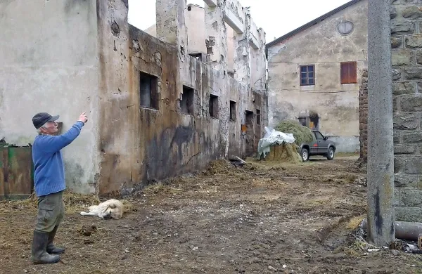 Stane Prosen kaže ostanke nadstreška ob hlevu; najprej so zagorele bale sena pod prvim 
oknom, nato pa so plameni zajeli kmetijske stroje in seno nad njimi, na koncu pa ves objekt.