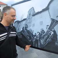 Robert Zabukovec pred fotografijo sekcije trobilcev pod mogočnim rudniškim gradom 
Gewerkeneg.