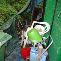 Za neugledno gostinsko prikolico je kup plastične krame. 