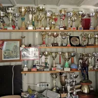Police v klubskem prostoru so polne osvojenih pokalov.

