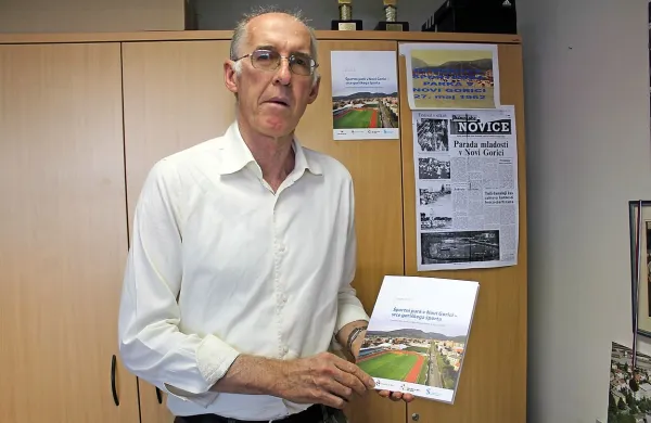 Vojko Orel z novo knjigo in s kopijo zapisa Primorskih novic 
ob otvoritvi novogoriškega stadiona leta 1962 v ozadju.