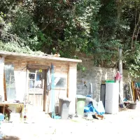 Pred zidano lopo je nekdo pustil delovno orodje, staro železo, 
odslužene hladilnike za pijačo,  steklovino in drugo šaro.