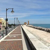 Manjša cerkvica ob koncu sprehajalne poti v Caorlah je videti, kot bi stala v morju.