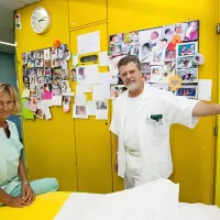 Neda Bizjak in Zvonko Šoštarič pred “steno sreče”, s katere 
se smejejo obrazi novih družin.  