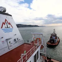 Vlačilci vlečejo in boksajo ladjo po navodilih pilota na ladji.