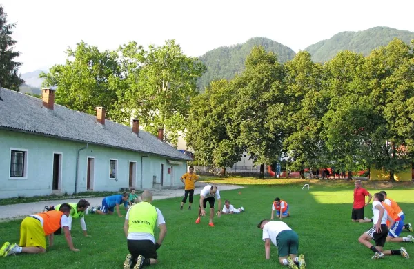 Nogometaši trenirajo pri dotrajanem “ležečem nebotičniku”.   