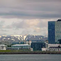 Pogled z zaliva na del islandske prestolnice, kjer se za zasneženimi hribi skrivajo ledeniki.