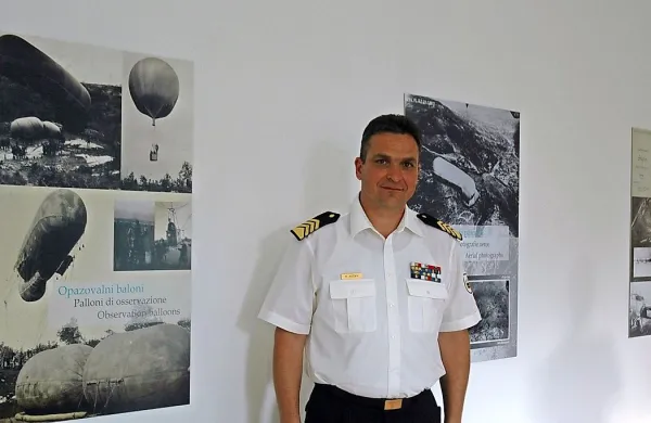 Avtor razstave Mitja Močnik ob razstavnih panojih. Eden med njimi prikazuje izvidniške balone.