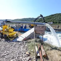  Nekaj vode vseeno steče mimo zagatnic v gradbeno jamo. 
Spraznijo jo s črpalko, ki pretoči kar 10.000 litrov v minuti.