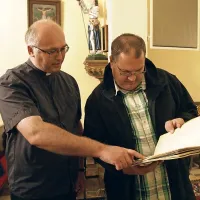Župnik  Milan Kavčnik (levo) in arhivar Tone Krampač z 
restavrirano krstno knjigo, v kateri so podatki za leta med 
1656 in 1721.  