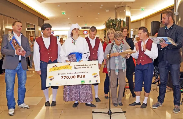 Koprski podžupan Peter Bolčič (skrajno levo) in odgovorni 
urednik regionalnega RTV centra Koper Matej Sukič (skrajno 
desno) sta zbrani denar simbolično predali predsednici 
društva Sožitje Zvezdani Rot. 