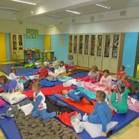 Smuknili so v spalne vreče in prisluhnili knjižničarju