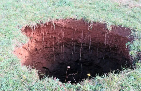 “V gozdu tam zgoraj sem nabiral gobe, nakar sem zaslišal 
zvok. Kot da bi nekdo razkladal drva s prikolice,” pove Rudi 
Zelko iz Dutovelj, ki je v petek  dopoldne naletel na skrivnostno luknjo.
