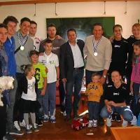 Novogoriška odbojkarska junaka Dejana Vinčiča in Sama 
Miklavca (z odličjema)  je skupaj z družinama in  delom 
navijačev sprejel novogoriški župan Matej Arčon (v sredini). 