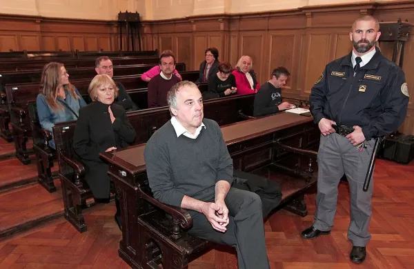   Milko Novič na sojenje prihaja iz pripora v spremstvu 
paznikov. 