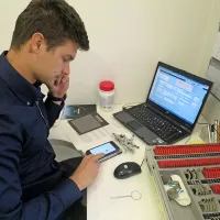 Matic Vogrič z računalniško aplikacijo v eni napravi in delom 
opreme, ki jo je za pregled oči potreboval doslej.