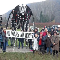 Protifašistična fronta brez meja je na protest v Dragonjo  
pripeljala svoj transparent z napisom No wars no wires 
(Nobenih vojn, nobenih žic).