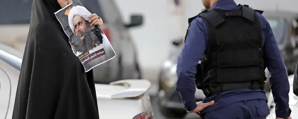 Protestnica v Bahrajnu s sliko  al Nimra, v Savdski Arabiji v soboto usmrčenega šiitskega verskega vodje.  