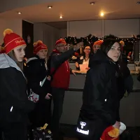 Rokometašice  v recepciji hotela z enotnimi rdečimi kapami, 
ki jih je sešila mama ene od igralk.
