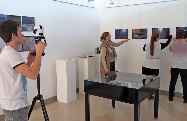 Študentje z laserjem in pod vodstvom Katje Gorup Pegan 
preverjajo, če se fotografije pravilno nameščene.