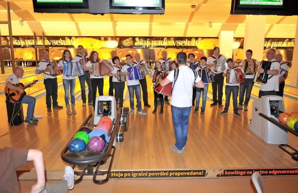 Dvajset članov orkestra Kraška harmonika je v ljubljanski 
Areni v četrtek poskrbelo za prijetno vzdušje 10. dobrodelnega bowling turnirja.  