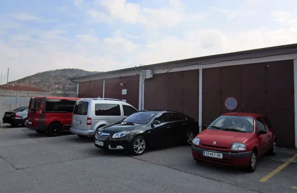 Vhod v - še po mnogih letih - začasne prostore glasbene  šole 
v Sežani je skozi druga garažna, ponavadi zaparkirana  vrata 
z leve. Prej je bil tu gasilski dom.  