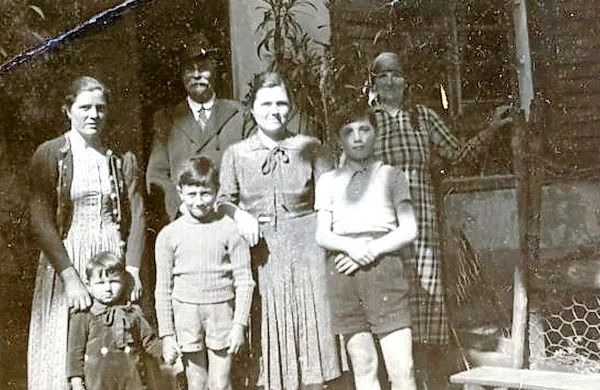 Na družinski fotografiji,  okrog leta 1945 posneti pred organistavo hišo v Dornberku,  Jožef Saksida stoji v ozadju.