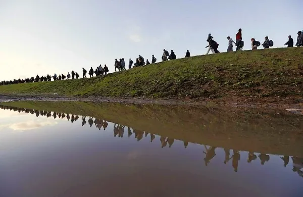Fotografija Srdjana Živulovića, posneta 20. oktobra lani na 
obrobju Brežic, prikazuje prebežnike na poti.