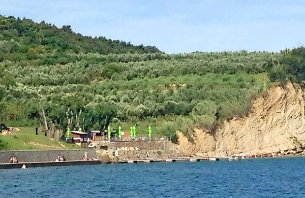 Pod Belvederjem je betonska plaža s pomolom.