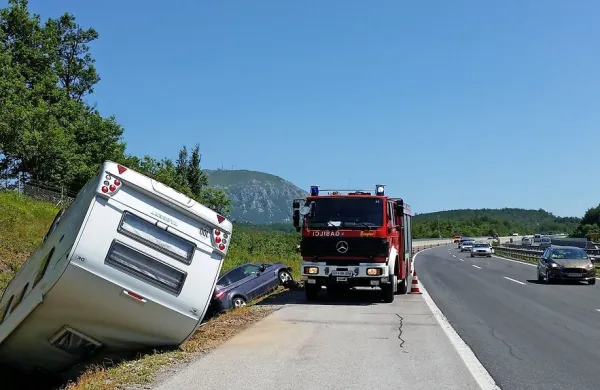 Avto s počitni&scaron;ko prikolico je pristal v jarku