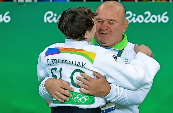 Končno nasmejani Miran Fabjan  čestita svoji tekmovalki in sveži olimpijski zmagovalki Tini Trstenjak.