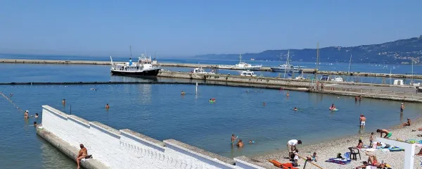 Zid, ki na tržaški plaži Laterna ločuje moški in ženski del, je ostanek nekoliko bolj sramežljivih, tradicionalno krščanskih časov, 
ko se to, da se je ženska pomanjkljivo oblečena kazala tujim moškim, ni spodobilo. Ironija tega, da  se je ravno ob tem zidu 
rodila zamisel o prepovedi burkinijev, je očitna.  
