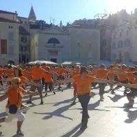 Tartinijev trg zažarel v oranžni barvi