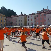 Tartinijev trg zažarel v oranžni barvi