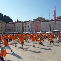 Tartinijev trg zažarel v oranžni barvi