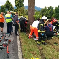 Nemški motorist se je ob trku v drevo poškodoval in prihranil poškodbe ženi.