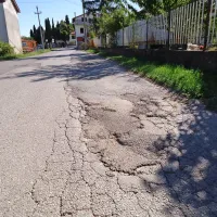 Udarne jame, poseden asfalt, razpoke - takšen je odsek 
ceste  med zadružnim domom in pokopališčem v Šmarjah. 