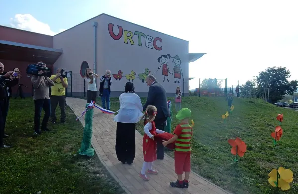 Trak ob novem vrtcu sta prerezala bistriški župan in ravnateljica vrtca ob pomoči dveh  malčkov, ki sta poosebljala 
vrtčev logotip (v ozadju). 