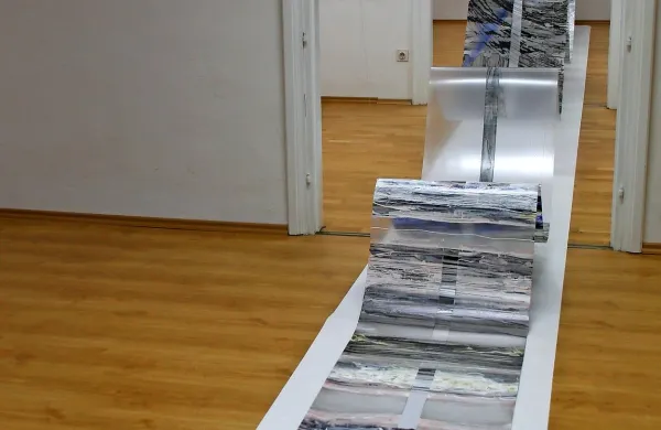  Skozi galerijo valovi več kot štirinajst metrov dolg, 45 
centimetrov širok in dva milimetra debel trak poslikane 
folije.