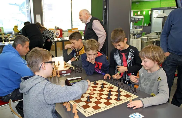 Četica najmlajših idrijskih šahistov in njihov mentor Silvo 
Kovač (stoji v ozadju).