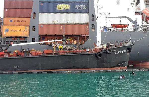 Tanker Capodistria je v pristanišču, zaščiten z baražami, 
oddal nafto kontejnerski ladji. 