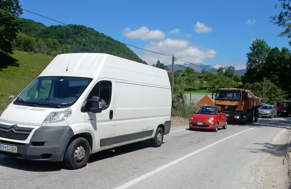 Kombiji različnih podjetij, tovornjaki in številni, ki se vozijo na 
delo in po opravkih, čakajo  pred semaforji.